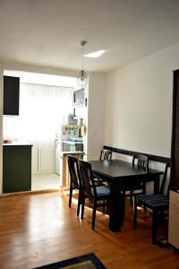 comedor con mesa y sillas y cocina en Three Aces Apartment, en Zemun