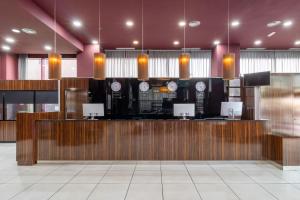 a lobby with a bar with clocks on the wall at Exe Convention Plaza Madrid in Madrid +37 photos