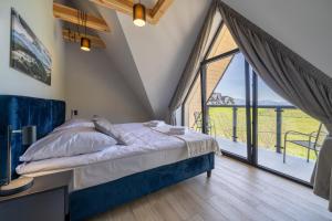 a bedroom with a bed and a large window at Silent Mountain Residence in Bukowina Tatrzańska