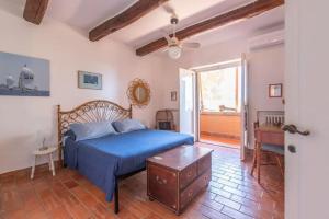 una camera con un letto blu e un tavolo di Villaflair - Villa Sbarcatello a Porto Santo Stefano