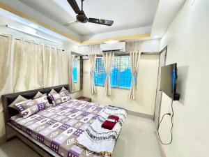 a bedroom with a bed and a flat screen tv at Stylish 1RK Serviced Apartment in Tollygunge in Kolkata