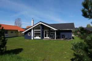 uma pequena casa azul com um jardim de relva em Resort 2 Sea Lodge C 42 em Grossenbrode