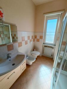 bagno con lavandino, servizi igienici e finestra di Affittacamere San Rocco ad Aramengo