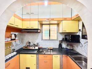 an archway in a kitchen with yellow and white cabinets at Stylish 1RK Serviced Apartment in Tollygunge in Kolkata