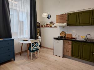 a kitchen with green cabinets and a small table at Charming studio in Tazacorte in Tazacorte