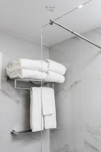 a towel rack with white towels in a bathroom at Nomad Houses - Ap Tereno in Beja +45 photos