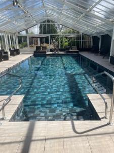 - une piscine avec des carreaux bleus dans un bâtiment dans l'établissement Grand Hôtel "Château de Sully" - Piscine & Spa, à Bayeux