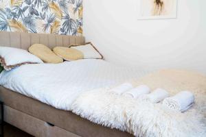 a bed with white blankets and pillows on it at Apartament Kulturalny in Sanok