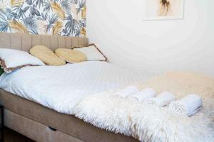 Una cama con mantas blancas y almohadas. en Apartament Kulturalny, en Sanok