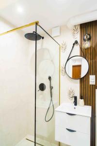 a bathroom with a shower with a sink and a mirror at Apartament Kulturalny in Sanok