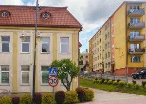 Una calle de la ciudad con edificios y una señal de velocidad. en Apartament Kulturalny, en Sanok