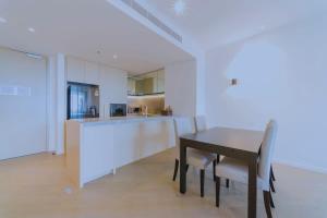 uma cozinha e sala de jantar com mesa e cadeiras em Fawkner Apartment Bay-view 4 em Melbourne