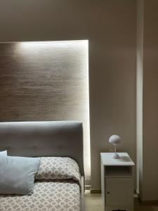 ein Schlafzimmer mit einem Bett und einem Tisch mit einer Lampe in der Unterkunft Central apartment in Avola