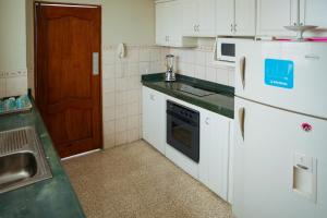 サリナスにあるCaptivating 4-Bedroom Apartment in Salinasのキッチン(白い家電製品、シンク付) +16枚の写真