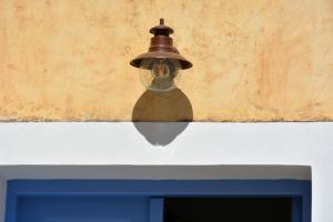 dzwon wiszący na ścianie nad niebieskim stołem w obiekcie Vori`s blue door country house w mieście Vóroi