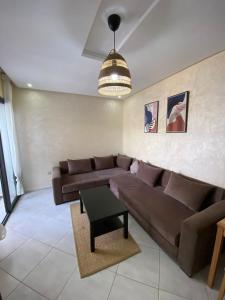 a living room with a brown couch and a table at Smir Park,Tetouan in Marina Smir