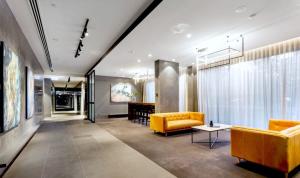 a living room with a yellow couch and a table at Camberwell Village ONE APT Smart TV in Melbourne