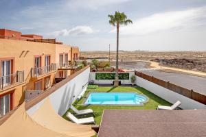an apartment with a swimming pool on the roof of a building at Villa del Relax in Corralejo