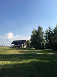 une maison au milieu d'un champ avec une grande pelouse dans l'établissement Beztroska Zatoka - agroturystyka, à Połajewo