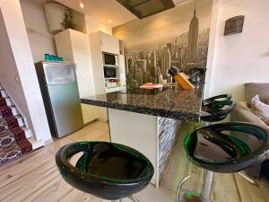 una cocina con una encimera con dos taburetes delante en Top DUPLEX-DELUXE APPARTEMENT-ALBATROS, en Puerto de la Cruz