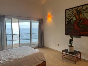 a bedroom with a bed and a view of the ocean at Paradis Villa breach front ocean view in Manzanillo