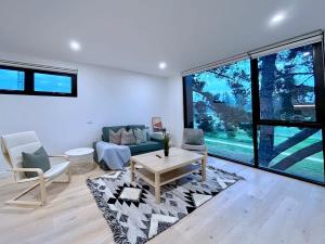 uma sala de estar com um sofá e uma mesa em Grandeur Innercity Townhouse em Melbourne