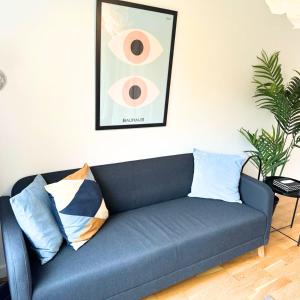 a blue couch with pillows in a living room at Newly refurbished 2 bed in Thame in Thame