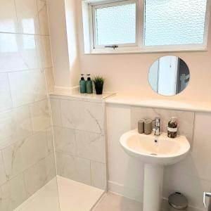 a white bathroom with a sink and a mirror at Newly refurbished 2 bed in Thame in Thame