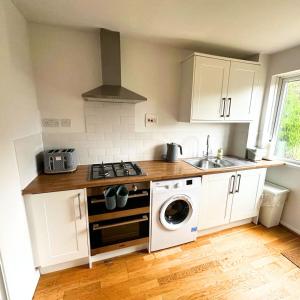 a kitchen with a stove and a washing machine at Newly refurbished 2 bed in Thame in Thame