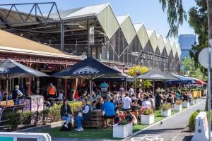 a group of people sitting under umbrellas outside a building at Modern 3-level Townhouse FreeParking in Melbourne