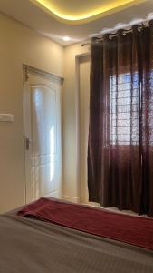 a room with a window and a door with a curtain at M premium executive apartment in Bangalore