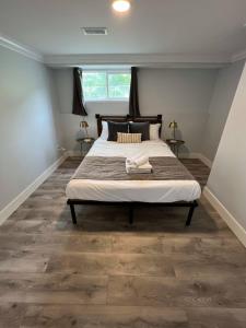 1 dormitorio con 1 cama grande y suelo de madera en River View House Basement en Kamloops