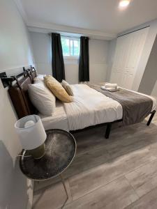 a bedroom with a bed with a table and a window at River View House Basement in Kamloops