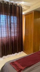 a bedroom with a bed and a window with curtains at M premium executive apartment in Bangalore