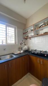 a kitchen with wooden cabinets and a sink and a window at M premium executive apartment in Bangalore