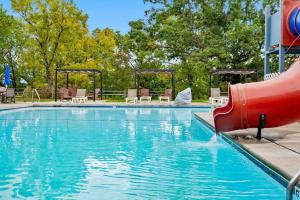 a pool with a red slide in the middle at Modern Rustic in Branson