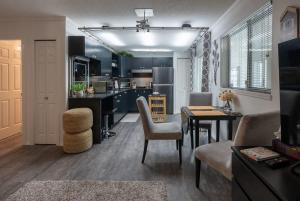 een keuken en een woonkamer met een tafel en stoelen bij Cherry Lane Suite - studio ground suite w garden in Nanaimo