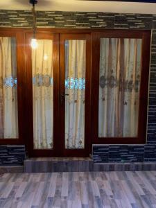 ein Paar Türen mit Vorhängen in einem Gebäude in der Unterkunft Ambulugala Home Stay in Gampola