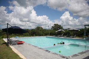 uma grande piscina com pessoas na água em Hacienda Familiar en Hato Mayor del Rey 