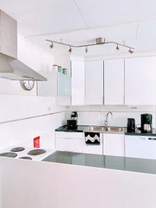 a white kitchen with white cabinets and a sink at Expe Finland in Porvoo