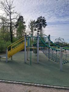 une aire de jeux avec un toboggan jaune dans un parc dans l'établissement Grand gîte des pins, à Chaumousey