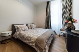 una camera con letto e vaso con fiori di Dream Suites Milano San Babila a Milano