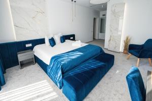um quarto com uma cama azul e um sofá azul em ALIVE HOTEL em Oradea