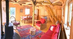 een woonkamer met een rode bank en een tafel bij Chalet avec bain nordique et sauna à Dabo in Dabo