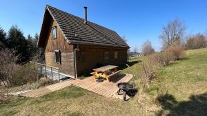 eine Holzhütte mit einem Picknicktisch und einem Grill in der Unterkunft Chalet avec bain nordique et sauna à Dabo in Dabo
