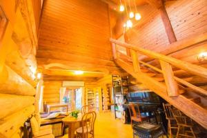 a room with a staircase in a wooden cabin at Yufuin Log House no Yado Tom Sawyer in Yufuin