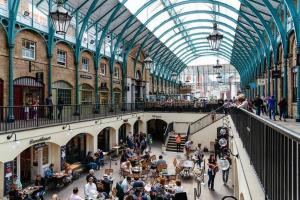 a crowd of people in a building with a glass ceiling at (Covent Garden) Cozy Apartment Central London in London