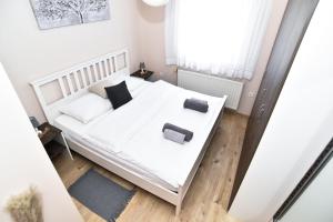 a bedroom with a white bed with two pillows at Apartman Podravina in Ludbreg