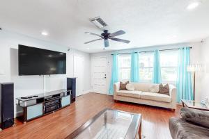 ein Wohnzimmer mit einem Sofa und einem Flachbild-TV in der Unterkunft Gecko Getaway in Fort Myers