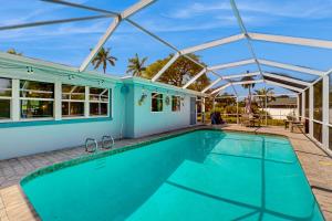 een zwembad in een huis met een dak bij Gecko Getaway in Fort Myers